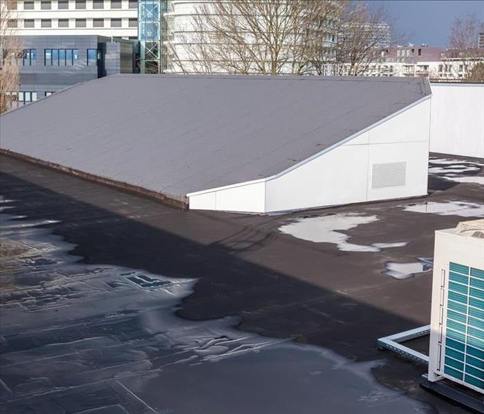 water pooling on large flat roof of commercial building